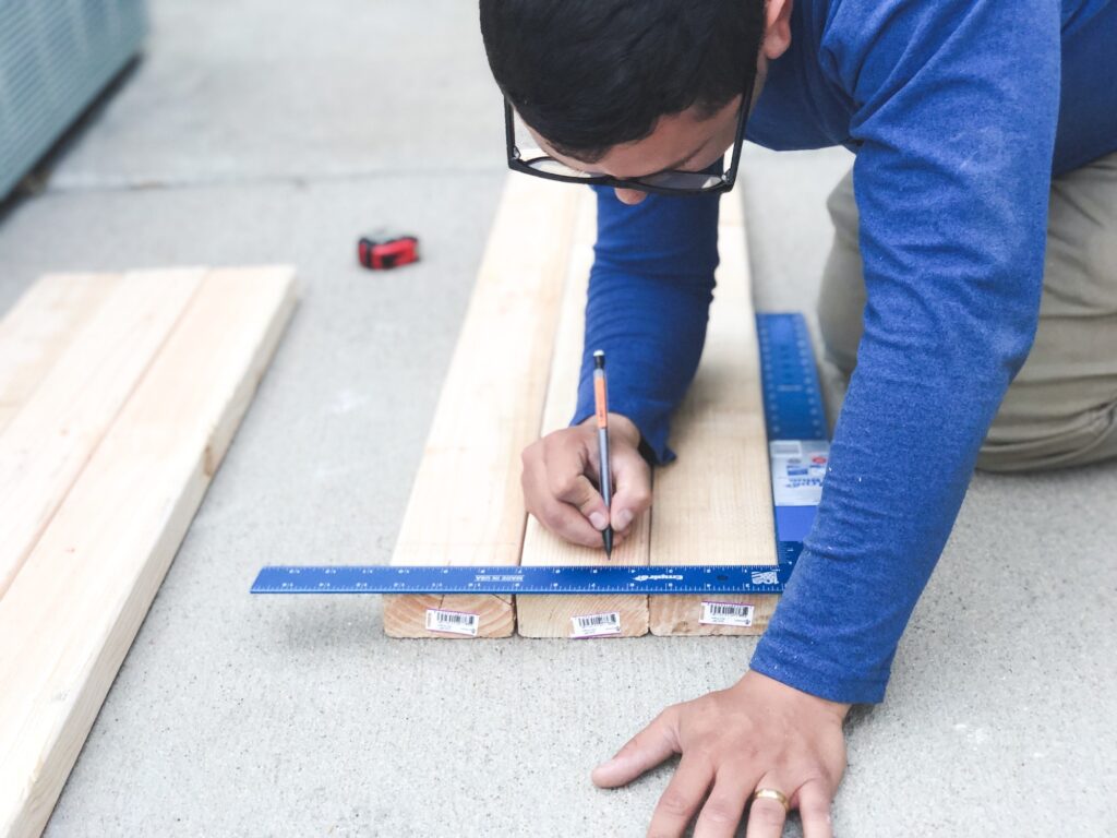 Man taking measurements on wood for a diy project